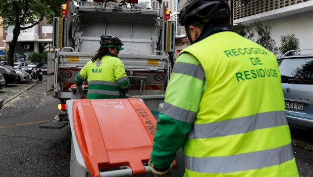 ep dos operarios de recogida de residuos protegidos con mascarilla trasladan cubos de basura