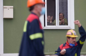 ep dos personas aplauden desde su ventana a la concentracion en la que piden solucion para la