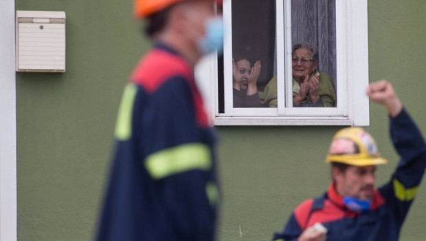 ep dos personas aplauden desde su ventana a la concentracion en la que piden solucion para la
