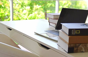 ep un escritorio con un ordenador portatil y varios libros