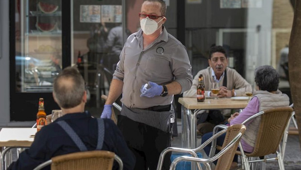 ep un camarero atiende la terraza de un bar el dia en el sevilla pasa a la fase 1 del plan de