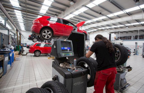 ep un empleado manipula un vehiculo en uno de los talleres que trabaja bajo cita previa y contando