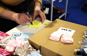 ep archivo   una mujer escribe los precios para sus productos en una feria de stocks