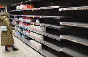 ep una mujer frente a la estanteria de leche que le faltan algunos productos