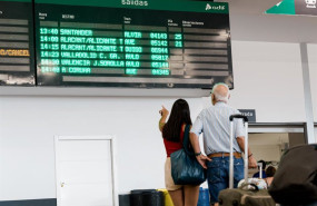 ep varias personas esperan con maletas junto a los carteles de salidas en la estacion chamartin
