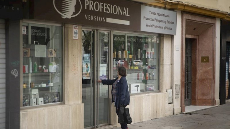 Una mujer en la puerta de una tienda de artículos de peluquería. Según el plan de desescalada del Gobierno central, las peluquerías podrán abrir el próximo lunes 4 de mayo. En Sevilla, (Andalucía, España) a 30 de abril de 2020. | María José López - Europa Press ep una mujer en la puerta de una tienda de articulos de peluqueria segun el plan de desescalada del