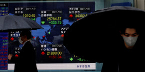 des hommes passent devant un tableau electrique affichant les indices nikkei et d autres pays devant une maison de courtage a tokyo 