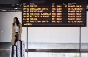 ep una mujer con maletas junto a un panel de salidas con diferentes destinos en atocha