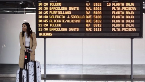 ep una mujer con maletas junto a un panel de salidas con diferentes destinos en atocha