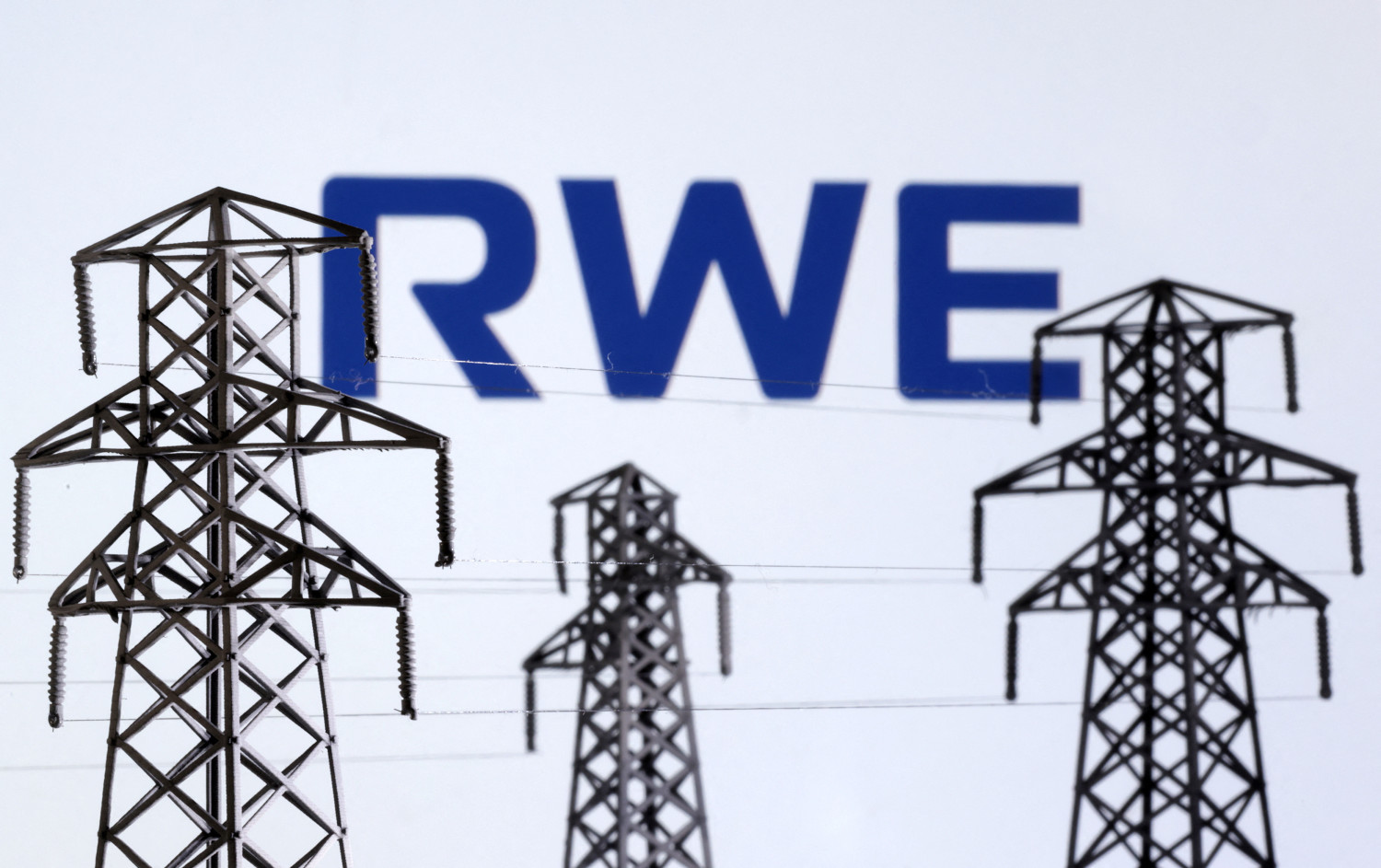 logo de rwe devant des miniatures de pylones de transmission d electricite 