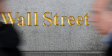 des personnes passent devant un panneau wall street pres de la bourse de new york 20250304075507 