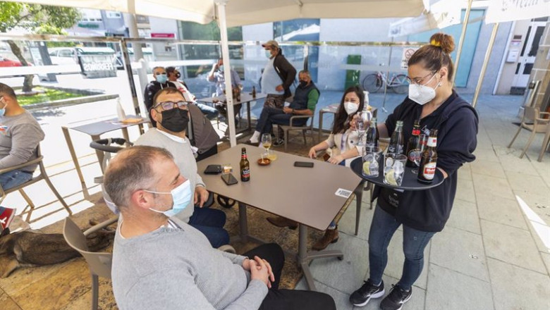 ep una camarera sirve en una terraza del municipio de o grove durante el primer fin de semana de