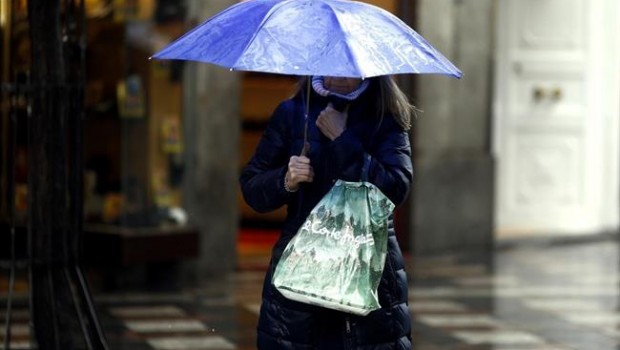 ep una mujer sostieneparaguas bajolluvia