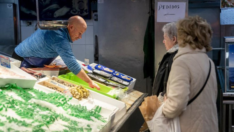 ep archivo   un trabajador autonomo atendiendo a dos clientas en su pescaderia