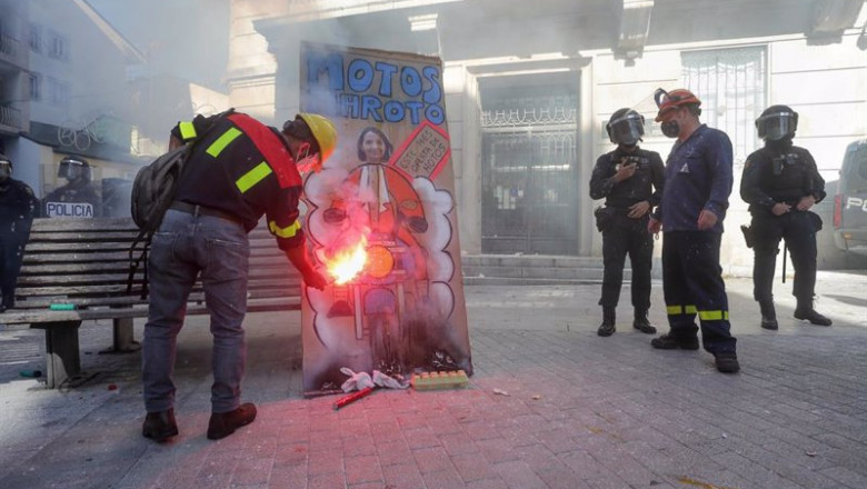 ep un hombre prende fuego a una pancarta con un retrato de la ministra de industria reyes maroto en