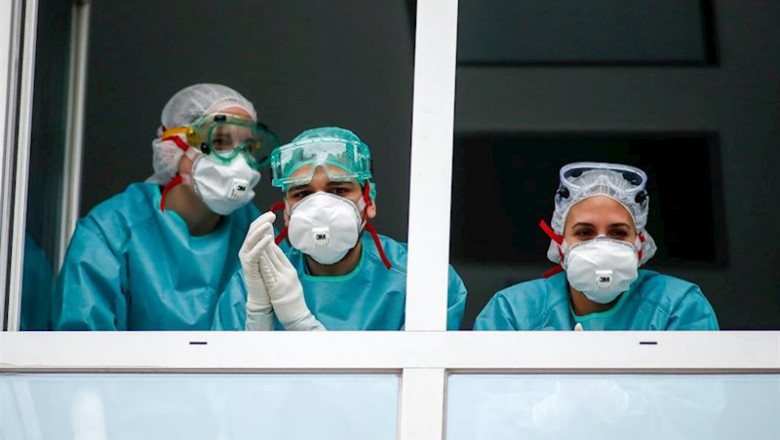 ep varios sanitarios con proteccion epi mascarillas gafas y guantes saludan desde una ventana del