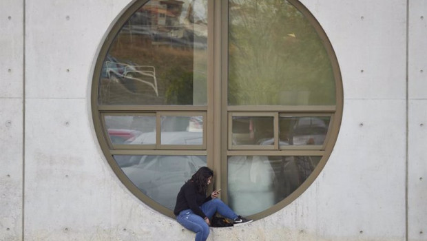 ep archivo   una estudiante consulta su movil junto a una ventana de la upna el dia en el que se