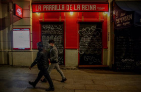 ep dos jovenes pasan por delante de un restaurante cerrado