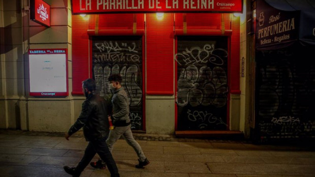 ep dos jovenes pasan por delante de un restaurante cerrado