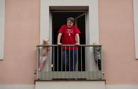 ep un hombre y sus dos hijos pequenos se asoman al balcon durante el segundo dia laborable del