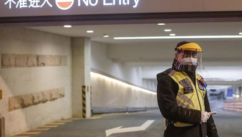 February 10, 2020, Shanghai China - A security guard in a surgical mask and a clear plastic visor holds an electronic thermometer and stands outside car park at the Kerry Center luxiury mall on West Nanjing Road, usually one of Shanghai's busiest streets. | Dave Tacon ep february 10 2020 shanghai china - a security guard in a surgical mask and a clear plastic visor