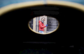 ep una mujer camina por la calle protegida con mascarilla y guantes sujetando su movil durante la
