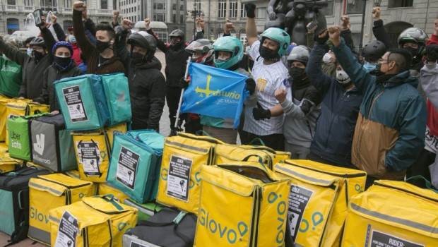 ep varios repartidores acumulan sus mochilas tras haber participado en una pitada en sus vehiculos
