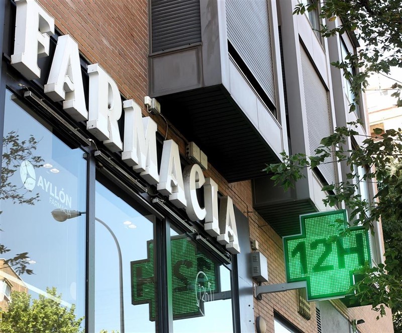 ep la entrada de una famacia con una senal luminosa de la cruz verde en la que pone 12h ep la entrada de una famacia con una senal luminosa de la cruz verde en la que pone 12h