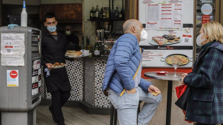 ep un camarero atiende a varios clientes en una terraza