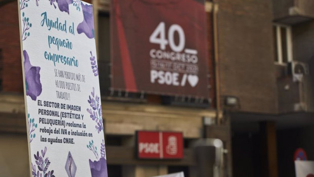 ep archivo   una profesional del sector de la peluqueria y estetica se concentra con una pancarta