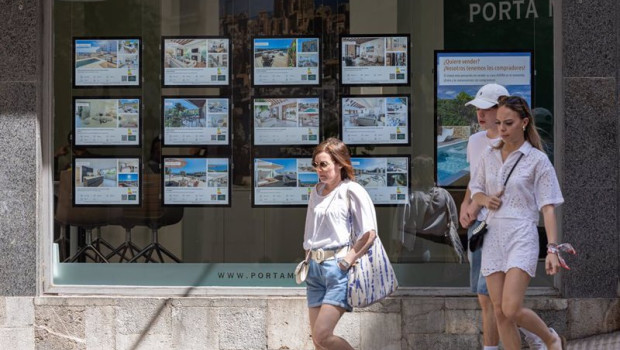 ep archivo   varias personas pasan junto a los anuncios de viviendas en venta en una inmobiliaria en