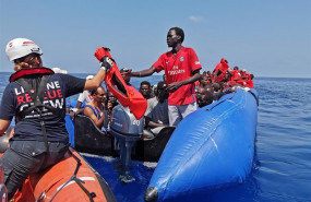 ep 26 august 2019 libya -- a rescue crew member gives a life jacket to an african migrant after he