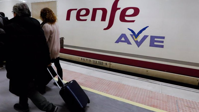 ep archivo dos pasajeros pasan por delante del primer tren comercial de alta velocidad desde ep archivo dos pasajeros pasan por delante del primer tren comercial de alta velocidad desde