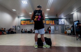 ep archivo   un joven junto a su maleta frente al panel de salidas en la estacion de tren de