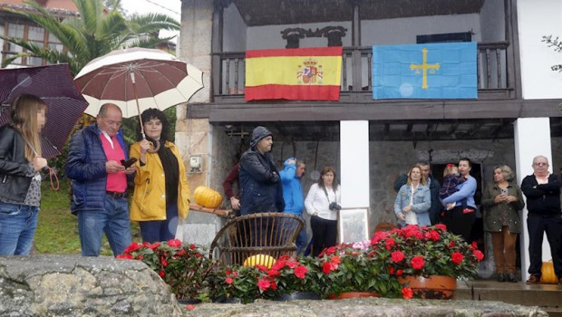 ep varias personas con paraguas por la lluvia esperando la llegada de la familia real a asiego