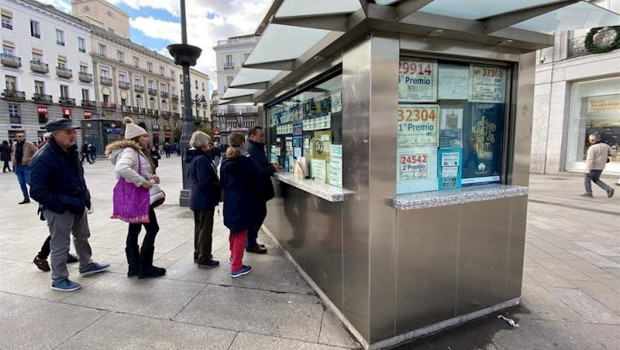 ep varias personas hacen cola para comprar un decimo de loteria de navidad en una administracion en