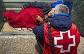 ep voluntario de cruz roja atendiendo a una persona sin hogar