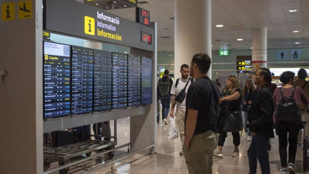 ep archivo   varias personas observan un panel de llegadas en el aeropuerto de barcelona a 4 de