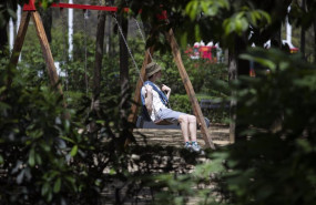 ep un turista vestido con ropa veraniega sentado en un columpio ep un turista vestido con ropa veraniega sentado en un columpio
