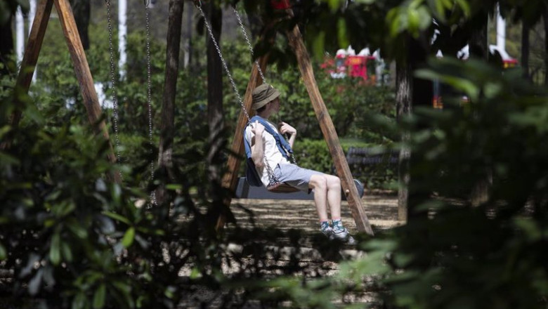 ep un turista vestido con ropa veraniega sentado en un columpio ep un turista vestido con ropa veraniega sentado en un columpio