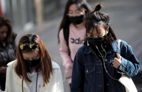 ep tres jovenes de rasgos asiaticos caminan por el distrito madrileno de usera protegiendo su rostro
