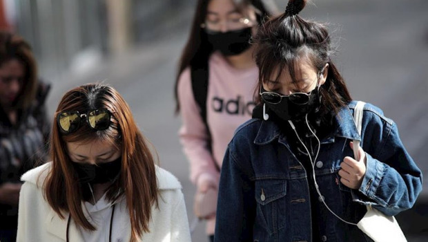 ep tres jovenes de rasgos asiaticos caminan por el distrito madrileno de usera protegiendo su rostro