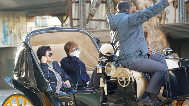 ep turistas con mascarilla paseando en coche de caballo por las calles de sevilla