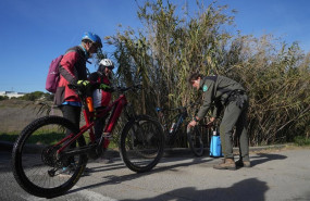 ep un agente rural de los mossos desquadra desinfecta las bicicletas de unos ciclistas en las zonas