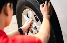 close up asian man inflating tire gas station 1 