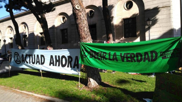 ep dos pancartas frnete al ministerio de transicion ecologica en las que se lee actitud ahora y