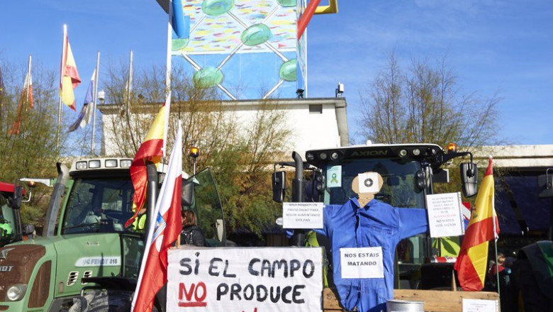 ep un tractor sostiene un pale con una pancarta en la que se lee si el campo no produce la ciudad no ep un tractor sostiene un pale con una pancarta en la que se lee si el campo no produce la ciudad no
