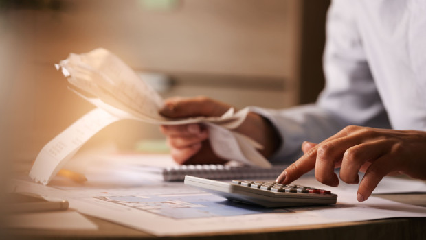 primer plano economista que usa calculadora mientras revisa facturas impuestos oficina 2 