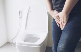 woman holding hand near toilet bowl health problem concept