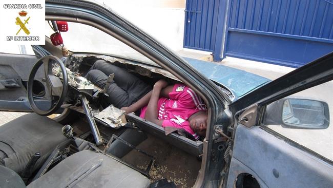 Inmigrante en el salpicadero de un coche en Melilla. | EUROPA PRESS/GUARDIACIVIL ep inmigrantesalpicaderoun cochemelilla